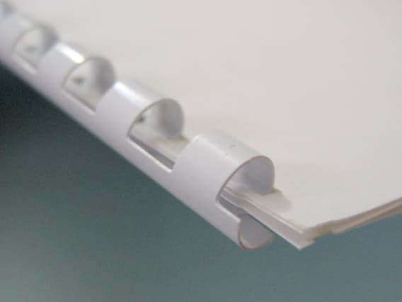 Close-up of plastic comb binding holding document pages